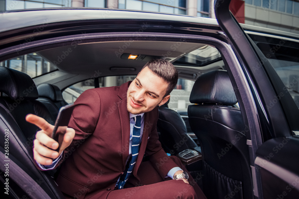 Smiling businessman sitting in a limo
