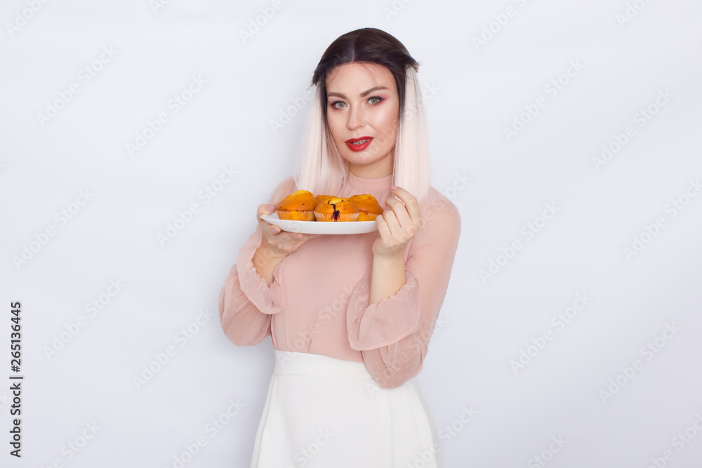 Blonde woman holding cakes on white plate Blonde woman holding cakes on white plate