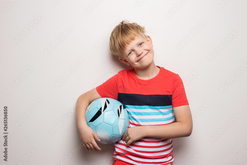 Cute little boy standing with soccer ball and looking at camera. Isolated on white. Studio portrait Cute little boy standing with soccer ball and looking at camera. Isolated on white. Studio portrait