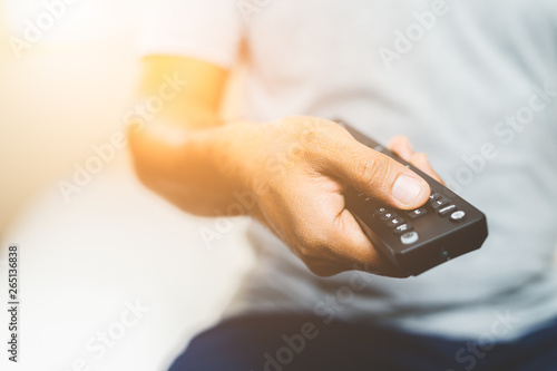 Hand man holding television remote.