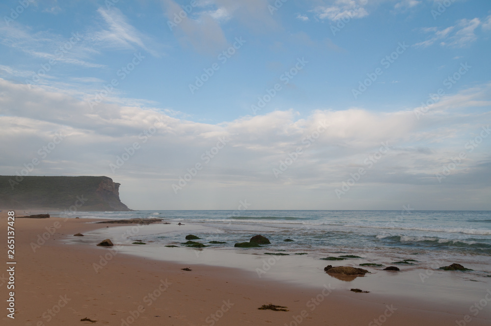 Empty beach with yellow sand and mild waves
