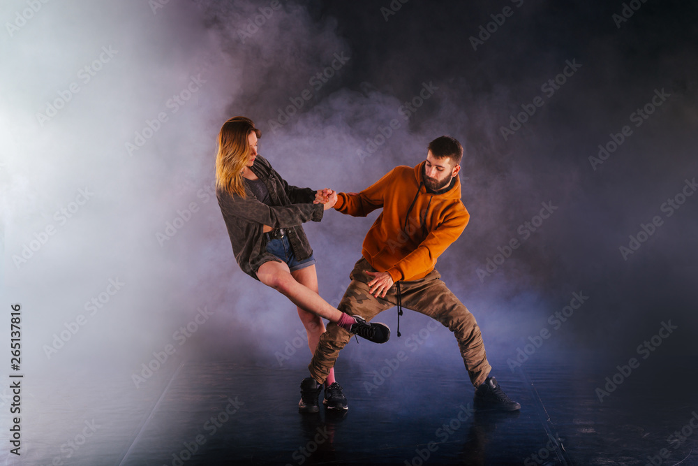 Dance couple shows off their moves the girl is throwing her leg high in the sky while the man is leaning back towards the ground. Dance couple shows off their moves the girl is throwing her leg high in the sky while the man is leaning back towards the ground.