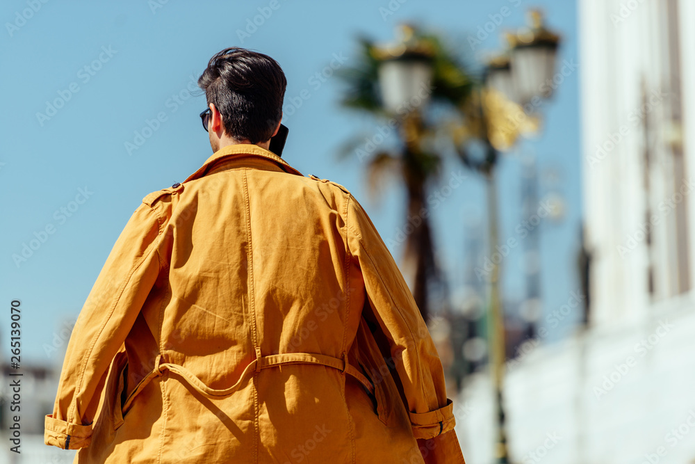 Businessman with yellow coat talking on mobile Businessman with yellow coat talking on mobile