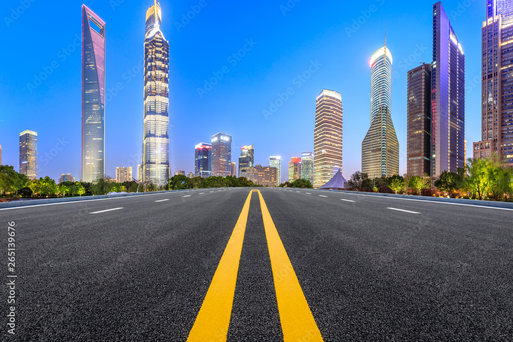 Shanghai modern commercial office buildings and straight asphalt road at night,panoramic view