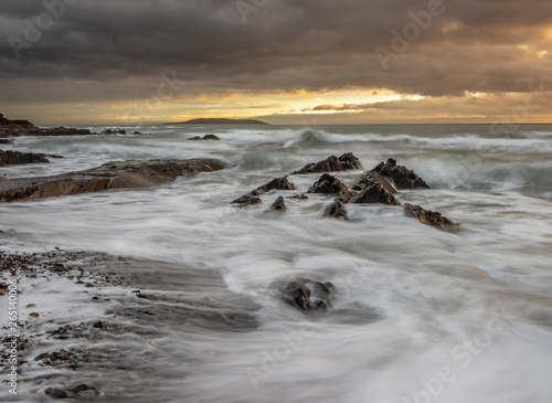 Moody seas, long exp of a winters sunrise on a beach. photo