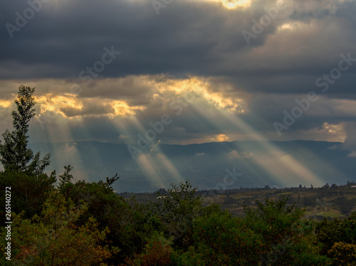 Multiple exposure of sunbeams casting their light over the valley at the Andean mountains of central Colombia.