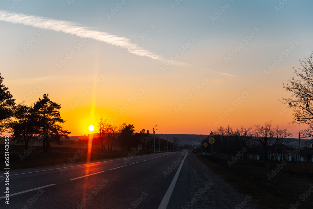 Landscape of unreal natural sunset on road from inside of car.