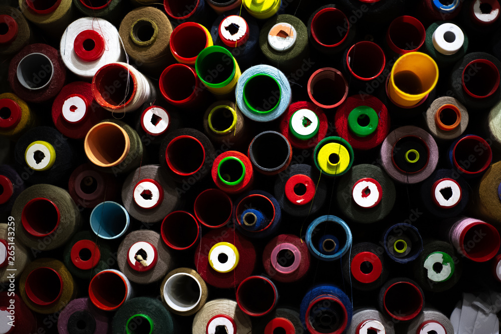 Dark background of colored thread coils for sewing
