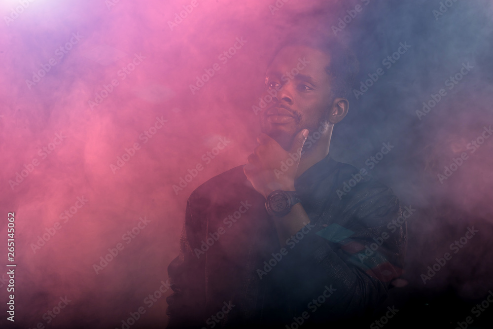 Portrait of handsome young African man on black background
