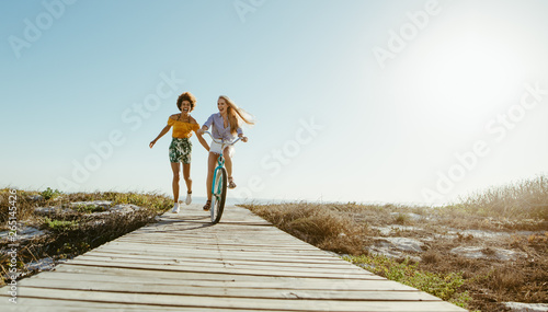 Friends with a bicycle on the seaside boardwalk