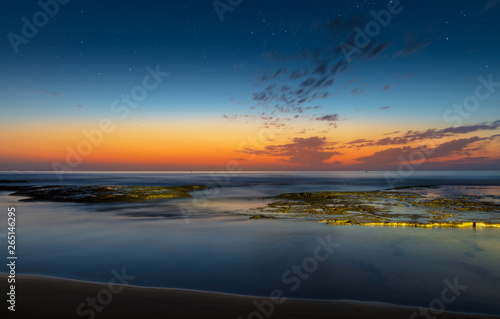 Beautiful colorful morning before sunrise on the coast south of Torrevieja near Campoamor with reflections in the water.