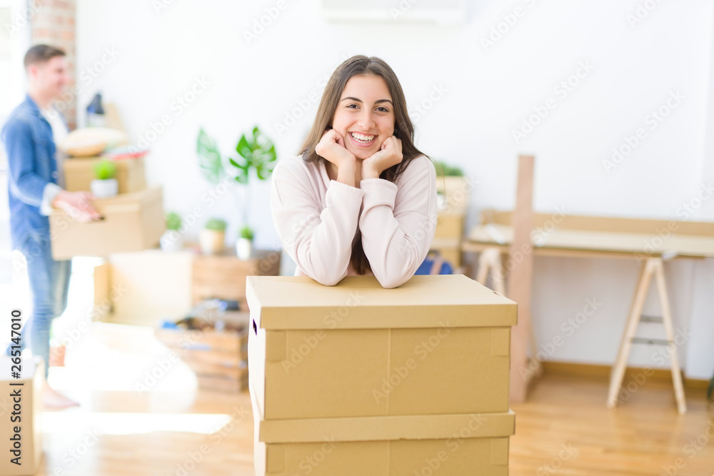 Beautiful young couple moving to a new home, young woman smiling happy to the camera excited for new apartment Beautiful young couple moving to a new home, young woman smiling happy to the camera excited for new apartment