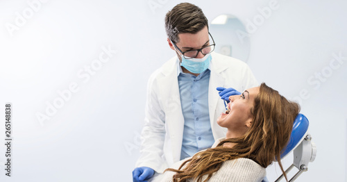 Dentist examining woman with dental equipments