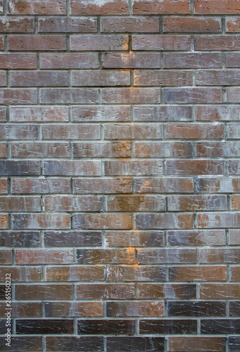 old wall of brown dark red and terracotta bricks with scratches and light cement spots. rough surface texture