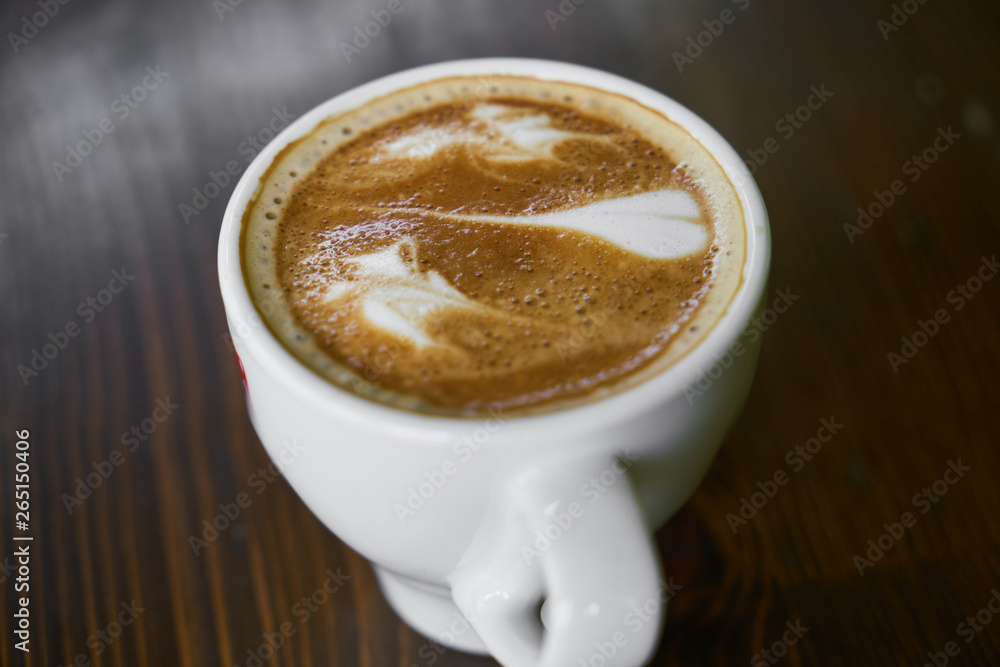 Obraz premium Cup of hot coffee latte on a wooden table
