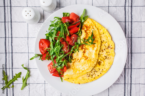 Принти на полотні Classic omelet with cheese and tomatoes salad on white plate, top view