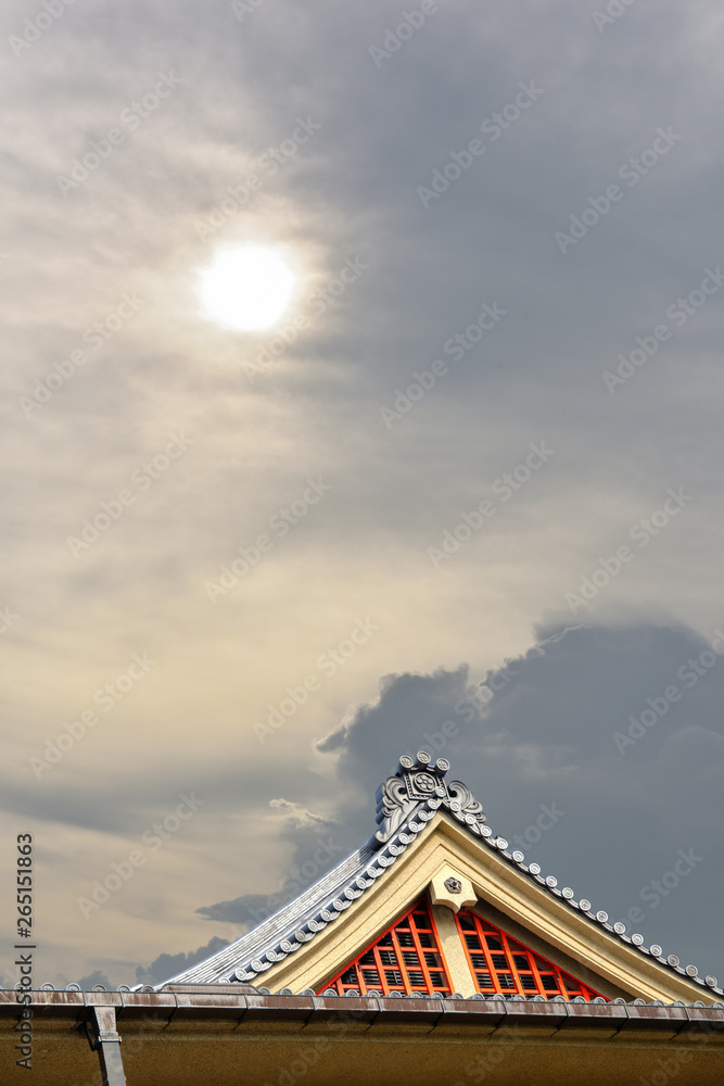 Antique Japanese buddhist temple showing roof structure; gable and tiles against the bright sky during the summer time. Reflecting the calmness and peaceful Japanese architecture.