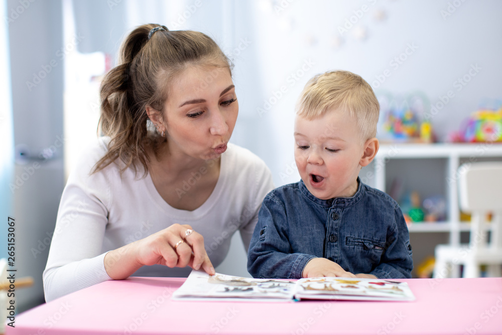 Speech therapist teaching letter pronunciation to kid boy in classroom Speech therapist teaching letter pronunciation to kid boy in classroom