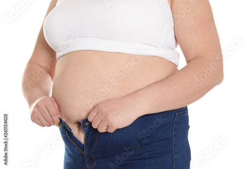 Overweight woman trying to wear tight jeans isolated on white, closeup