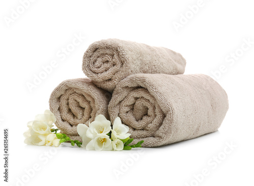 Clean rolled towels with flowers on white background