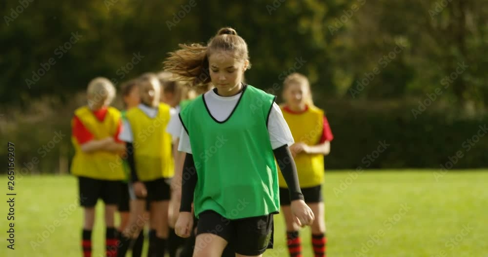 4K Young female soccer team practising ball control & dribbling on school sports field. Slow motion. 4K Young female soccer team practising ball control & dribbling on school sports field. Slow motion.