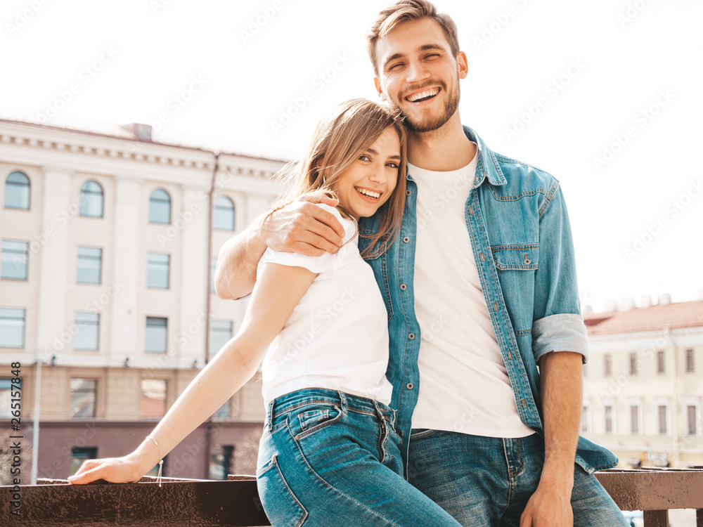 Smiling beautiful girl and her handsome boyfriend in casual summer clothes. Happy cheerful family having fun on the street background