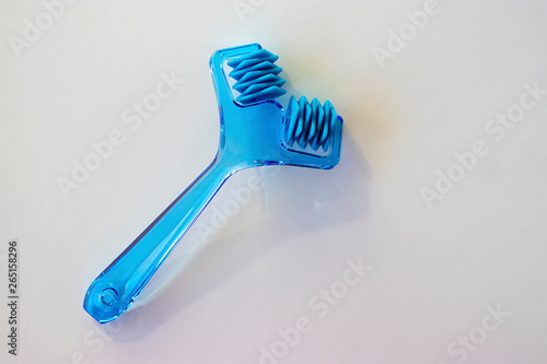 Plastic blue facial massager on a white background.