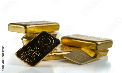 A bunch of different gold bullion isolated on a white background. Selective focus.