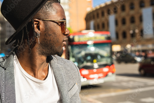 Guy with hat dressed in style and modern in the city. African american guy