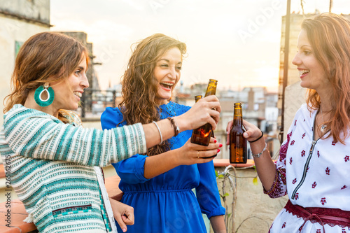 Happy women enjoying a beer on a rooftop in Barcelona