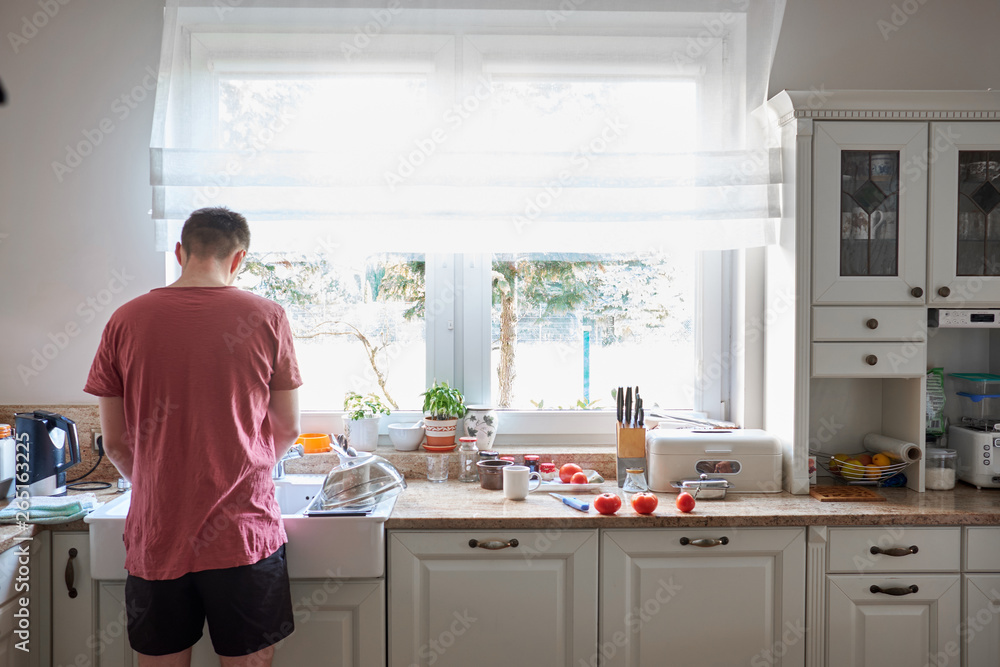 Caucasian man washing dish at kitchen