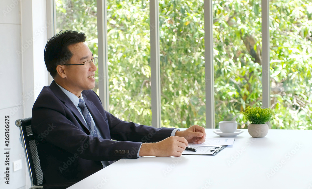 Senior asian businessman working on document at his office desk, business people, office lifestyle concept Senior asian businessman working on document at his office desk, business people, office lifestyle concept