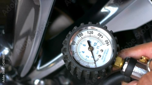 Asian man car inspection Measure quantity Inflated Rubber tires car.Close up hand holding machine Inflated pressure gauge for car tyre pressure measurement for automotive, automobile image