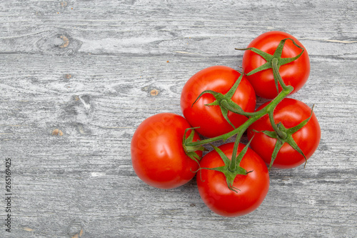 tomatoes on a branch isolated on a wooden background