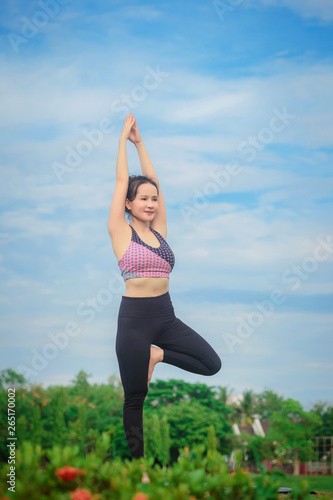 Young Asian woman practicing yoga in the park