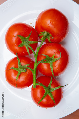tomatoes on a branch in a white plate © Андрей Юсенков