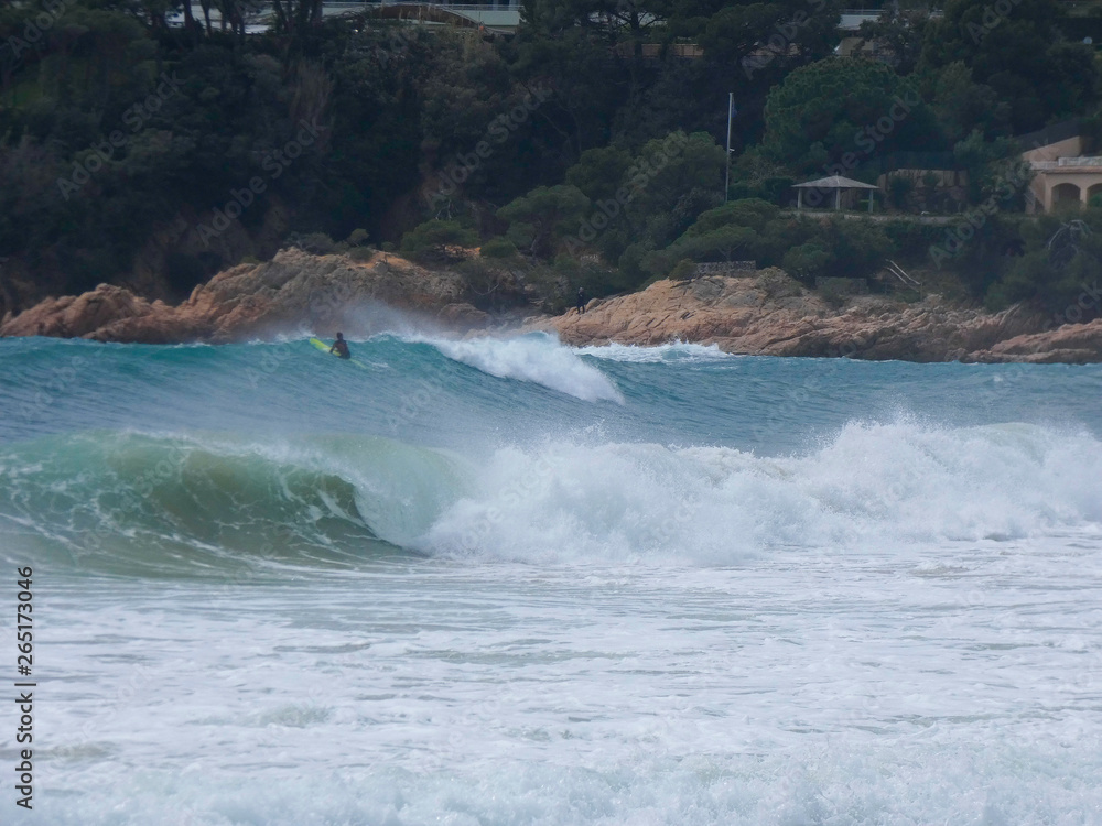 Olas rompiendo en la playa y surfistas esperando la Ola para cabalgarla