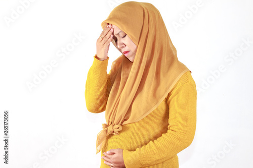 Pregnant woman suffering with nausea, asian woman wearing hijab isolated over white background