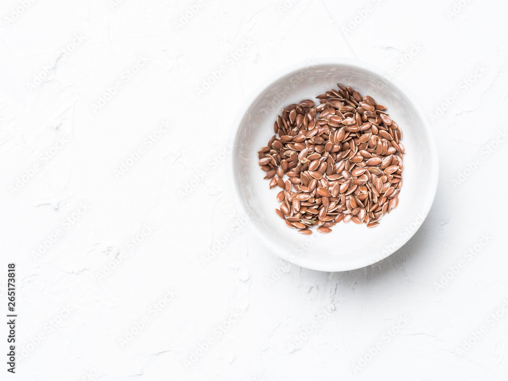 Flax seeds with copy space. Brown flax seed on white concrete textured background. Top view or flat lay. Copy space. Healthy food and diet concept Flax seeds with copy space. Brown flax seed on white concrete textured background. Top view or flat lay. Copy space. Healthy food and diet concept