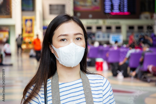 Asian woman masked a protective mask in public area close up.