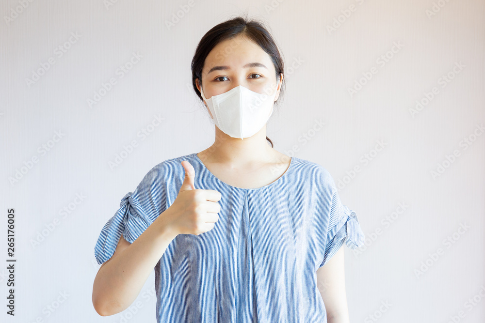 Asian woman masked a protective mask and showing trumb up sign. Asian woman masked a protective mask and showing trumb up sign.