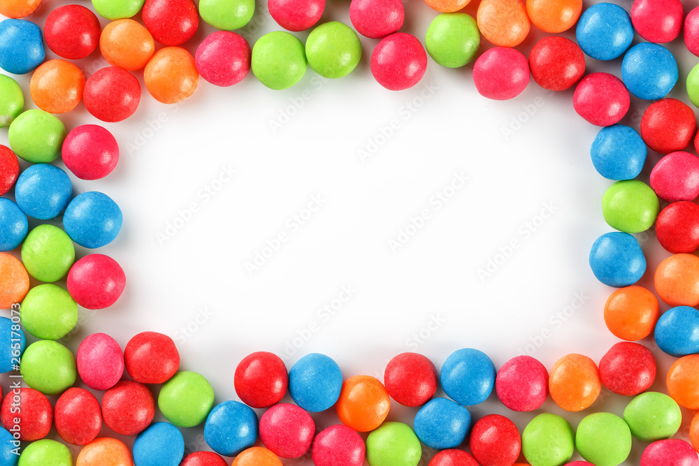 Frame of multi-colored candies close up. Rainbow colored dragee multicolored glaze on a white background Frame of multi-colored candies close up. Rainbow colored dragee multicolored glaze on a white background