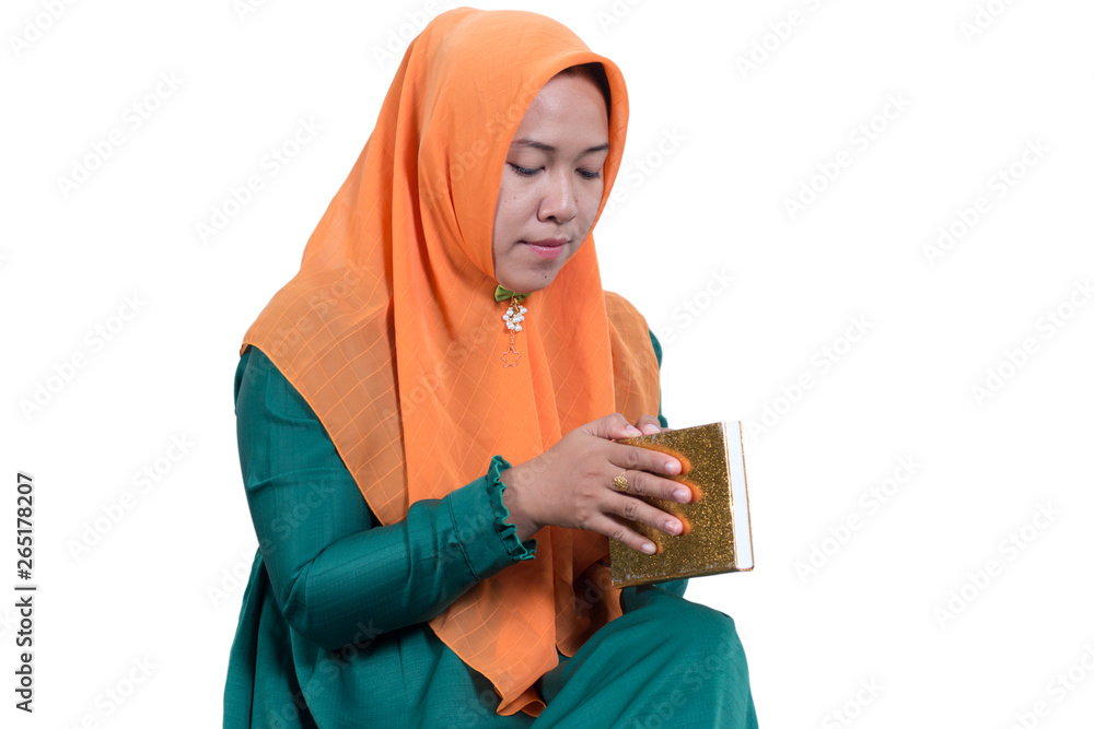 Portraits of young Asian Muslim business women wearing hijab And Reading The Holy Quran, isolated on white background Portraits of young Asian Muslim business women wearing hijab And Reading The Holy Quran, isolated on white background
