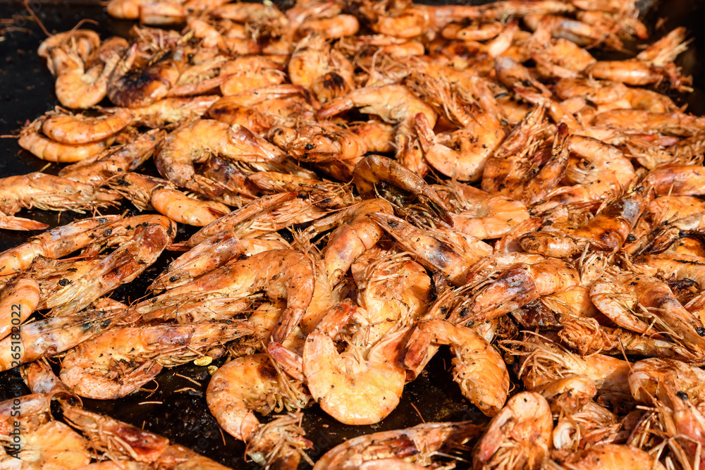 Close up of a large portion of shrimps prepared on a hot grill in display at a street food market Close up of a large portion of shrimps prepared on a hot grill in display at a street food market