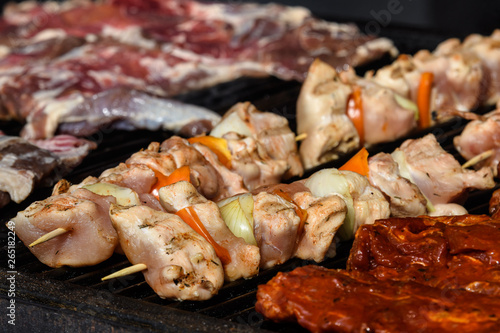 Skewers with chicken and vegetables cooking on a hot grill, soft focus