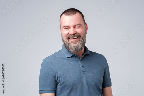 Caucasian mature man laughing on funny joke. photo