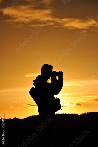 Silhouette of photographer against setting sun