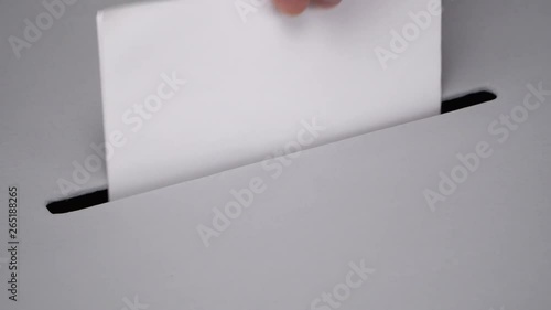 Close-up gray ballot box. Presidential and parliamentary elections. The voter throws the ballot into the ballot box.