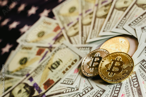Bitcoins and 100 dollar bills with american flag background.