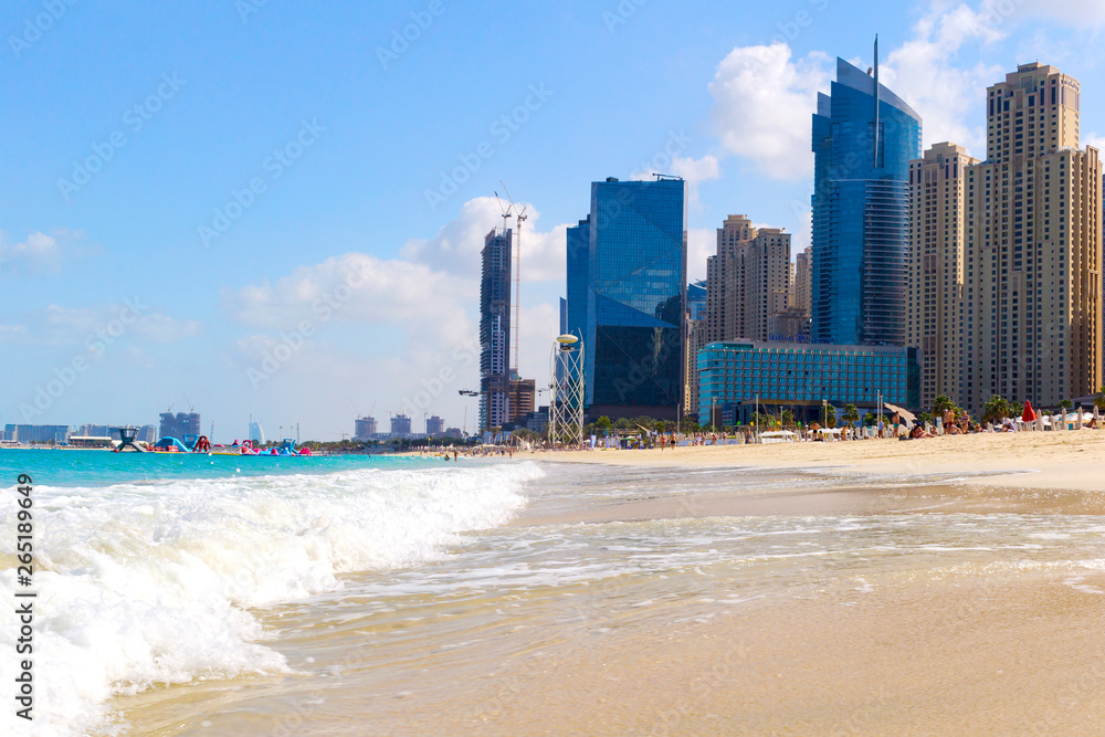 Naklejka premium Beach and skyscrapers at Jumeirah beach in Dubai marina and sunbeds.UAE